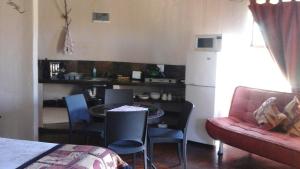 a living room with a table and a couch and a kitchen at African Sun Guest House in Molen Drift