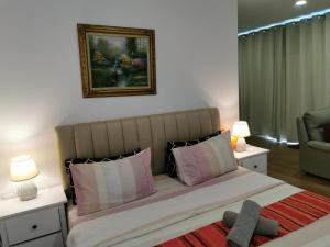 a bedroom with a large bed with pink and white pillows at Apple 4@Menara Simfoni/King Bed/Wifi/Netflix/TVBOX in Cheras