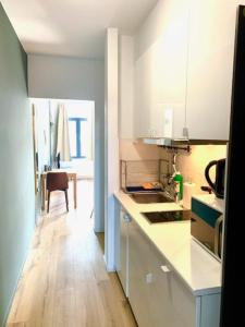 a kitchen with white cabinets and a wooden floor at Sam in Antwerp in Antwerp