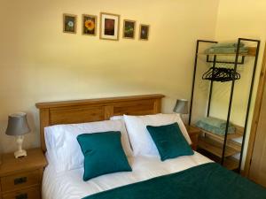 a bedroom with a bed with two green pillows at 1 bedroomed Detached holiday retreat Pant in Oswestry