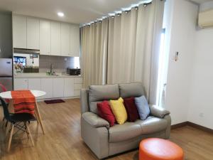 a living room with a couch with colorful pillows on it at Apple 4@Menara Simfoni/King Bed/Wifi/Netflix/TVBOX in Cheras