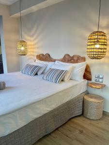 a bedroom with a large white bed with two lights at Corfu Gaia View Studio in Episkopianá