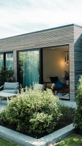 ein Haus mit Glasschiebetüren und einer Terrasse in der Unterkunft B&B De Tiendeschuur in Evergem