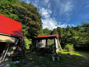 ein Haus mit rotem Dach und Treppen neben Bäumen in der Unterkunft 帳 -TOBARI- in Dazaifu