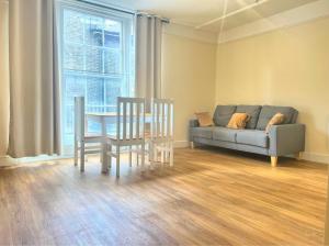 a living room with a couch and a table and chairs at Modern Apartment -Ipswich - Great Location in Ipswich