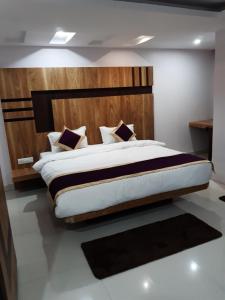 巴特那的住宿－Hotel Crown Palace，一间卧室配有一张大床和木制床头板