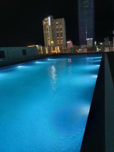 a large swimming pool with a city at night at FLC SEA TOWER - Quy Nhơn in Quy Nhon