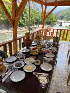 a table with food on it with a view of a river at Karadeniz Suit in Rize