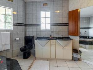 a bathroom with a toilet and a sink at Gannet Place Guest House in Hazyview