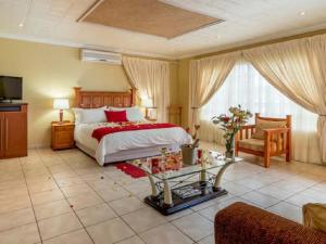 a bedroom with a bed and a table in a room at Gannet Place Guest House in Hazyview