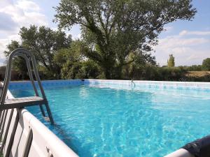 una piscina blu con una sedia di LOCATION APPART 45 M² - 2 CH AVEC JARDIN PRIVATIF a Gailhan