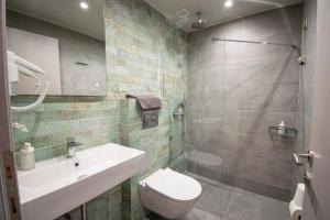 a bathroom with a toilet and a sink and a shower at Heraclea Luxury Suites in Nea Iraklia