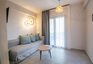Heraclea Luxury Suites في نيا إيراكليا: غرفة معيشة مع أريكة وطاولة