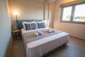 a bedroom with two beds and a window at Heraclea Luxury Suites in Nea Irakleia