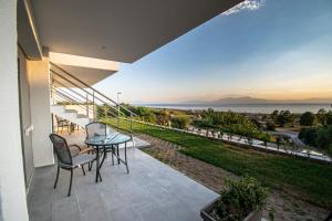 a patio with a table and chairs and a view of the ocean at Heraclea Luxury Suites in Nea Irakleia +40 photos