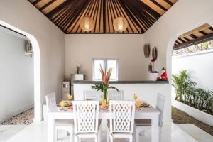 a dining room with a white table and chairs at Villa Shanti Bingin in Uluwatu