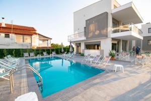 a swimming pool in front of a house at Heraclea Luxury Suites in Nea Iraklia