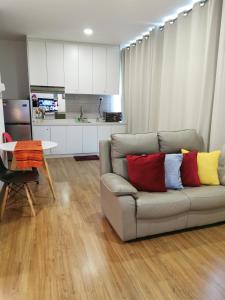 a living room with a couch with two colorful pillows at Apple 4@Menara Simfoni/King Bed/Wifi/Netflix/TVBOX in Cheras
