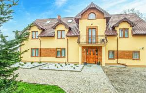 une grande maison jaune avec une porte en bois dans l'établissement Gorgeous Apartment In Polchowo With Wifi, à Połchowo