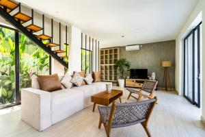un soggiorno con divano e tavolo di Joy Villa by Hombali a Canggu