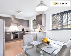 eine Küche und ein Esszimmer mit einem Glastisch und Stühlen in der Unterkunft LONG STAYS 30pct OFF - Comfy 3 Bed House near City Centre - PS4 - PARKING By Klarok Short Lets & Serviced Accommodation in Peterborough