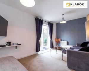 ein Wohnzimmer mit einer Couch und einem Fenster in der Unterkunft LONG STAYS 30pct OFF - Comfy 3 Bed House near City Centre - PS4 - PARKING By Klarok Short Lets & Serviced Accommodation in Peterborough