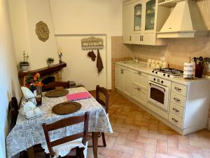 a kitchen with a table and a stove at Casina di Rosa in Civitella Marittima