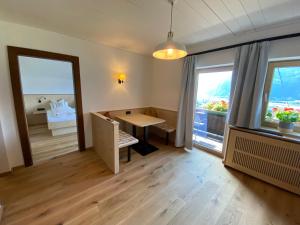 een kamer met een tafel en uitzicht op een slaapkamer bij Waldruh in Wiesing