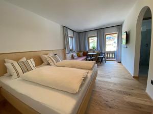 a bedroom with two beds and a living room at Waldruh in Wiesing