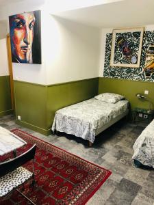 Un dormitorio con dos camas y un cuadro en la pared. en PAPILLONS De Nuit Champagne Troyes, en Troyes