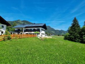 a house on a green field with a fence at Zollhaus 65 in Reit im Winkl