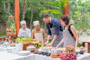 a group of people standing around a table with food at Pilgrimage Village Boutique Resort & Spa in Hue