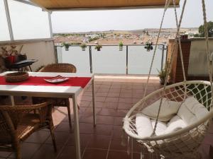a swing on a balcony with a table and a table at Ático Love in Jerez de la Frontera