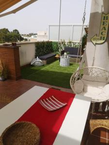 a patio with a hammock and a table and chairs at Ático Love in Jerez de la Frontera