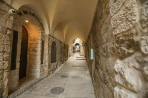 Une allée avec des arches dans un ancien bâtiment dans l'établissement Western Wall Luxury House, à Jérusalem