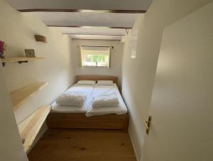 Cama pequeña en habitación pequeña con ventana en Ferienwohnung Haus am Uckersee, en Prenzlau