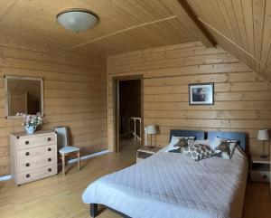 - une chambre avec un lit et un mur en bois dans l'établissement Vilni Vitry, à Osmoloda