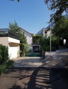 uma casa com uma entrada com uma cerca e um edifício em Rooms Ana em Kotor