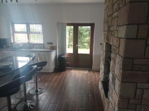 a kitchen with a brick wall and a table and a door at 3 bedroom detached bungalow in Dromore +35 photos
