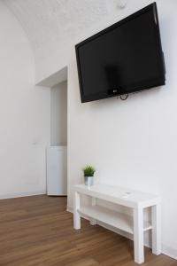 - un salon avec une table blanche et une télévision murale dans l'établissement Terrasini 2000 Home Holidays, à Terrasini