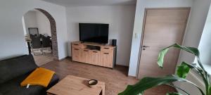 a living room with a couch and a flat screen tv at Ferienhaus Thalia 3 in Übach-Palenberg