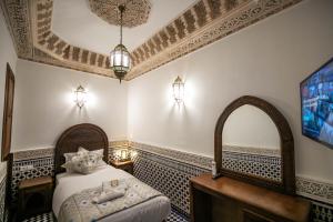 a bedroom with a bed with a sink and a mirror at Riad Sidrat Fes in Fès