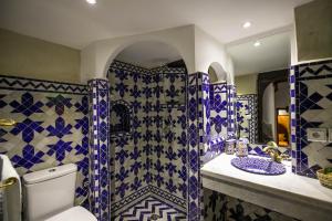 uma casa de banho com azulejos azuis e brancos na parede em Riad Sidrat Fes em Fez