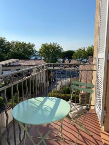 a balcony with a blue table and chairs on it at Superbe studio avec balcon vue mer à 100m de la plage in Saint-Tropez