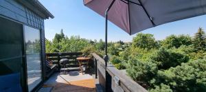 un patio con sombrilla y una mesa en una terraza en Ferienwohnung am Park, en Leipzig