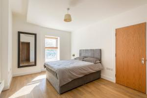 a bedroom with a bed and a mirror and a door at Prime Location Flats in London