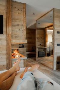 a man laying on a bed in a room with a fireplace at Sci Sport rooms & suites in Bormio