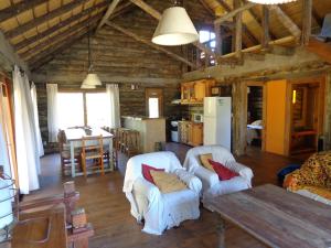 uma sala de estar com duas cadeiras brancas e uma mesa em Cabaña Navajuá em La Paloma