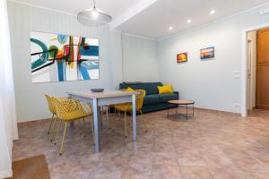 a living room with a table and chairs and a couch at Teo House Beach in Taormina