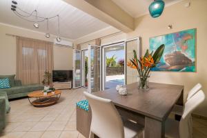 a dining room with a table and chairs and a living room at Madini Luxury villa with private heated pool in Vanáton